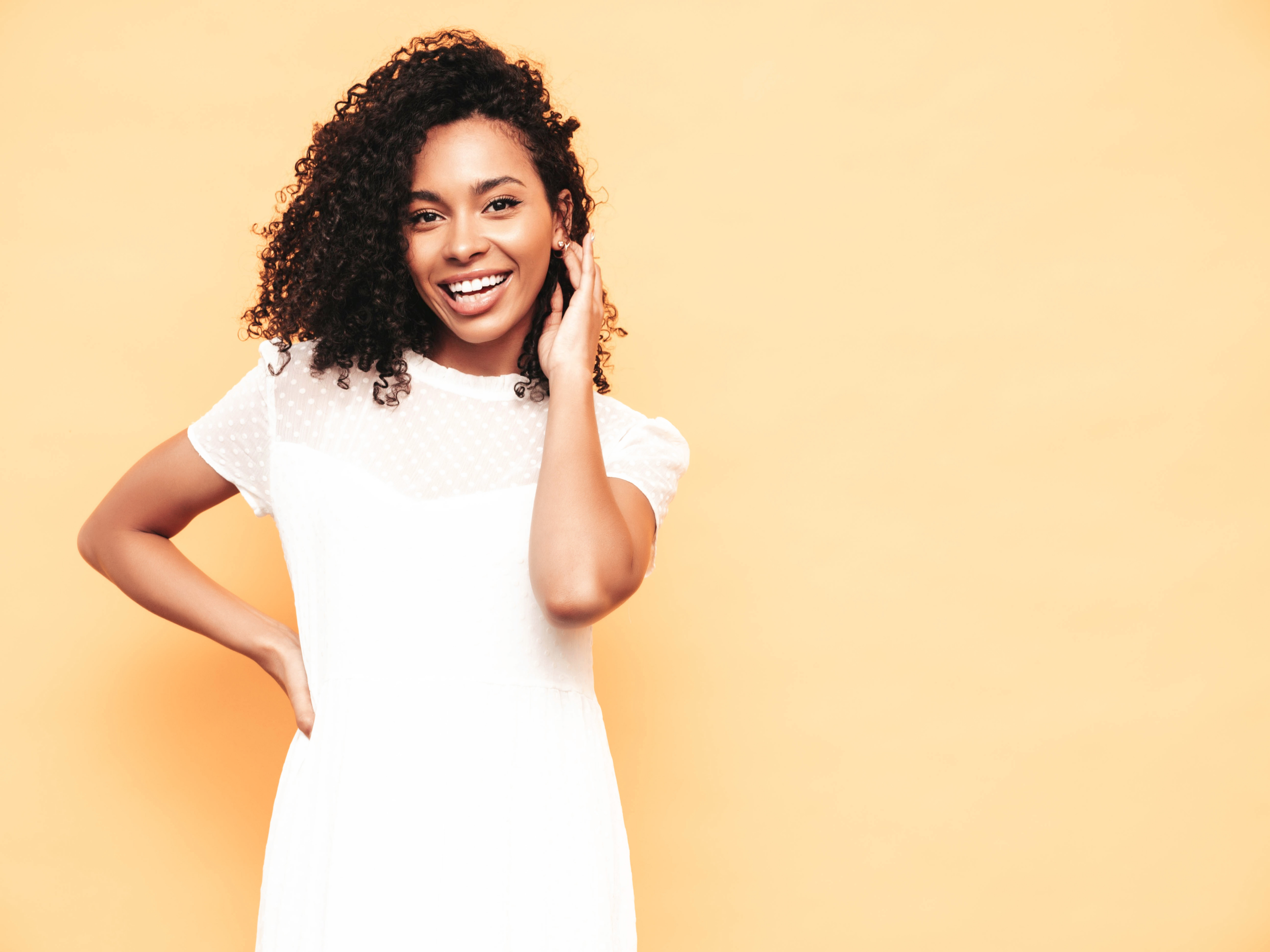 Happy Black woman smiling warmly in a bright studio portrait.